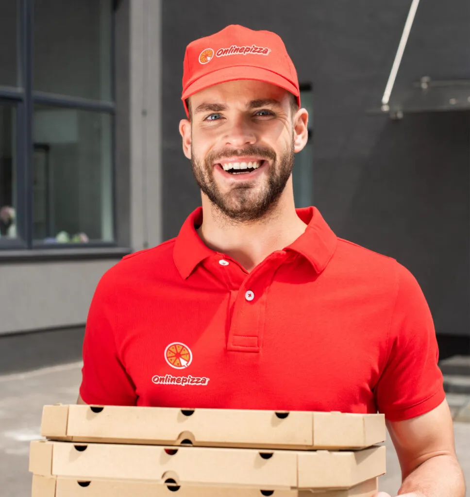 smiling caucasian courier holding boxes with pizza